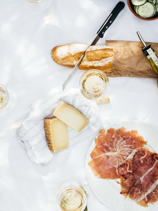 A crusty baguette and a glass of white wine on a bright table