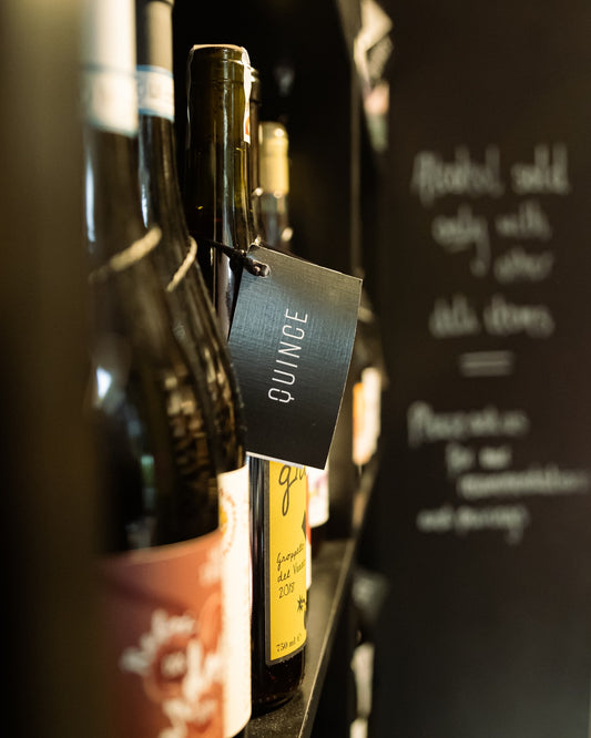 A row of wine bottles resting in the Quince cellar
